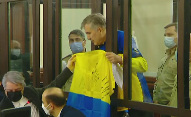 "დიდება უკრაინას!" - მიხეილ სააკაშვილმა პროცესზე უკრაინის დროშა გაშალა და ჰიმნი შეასრულა.