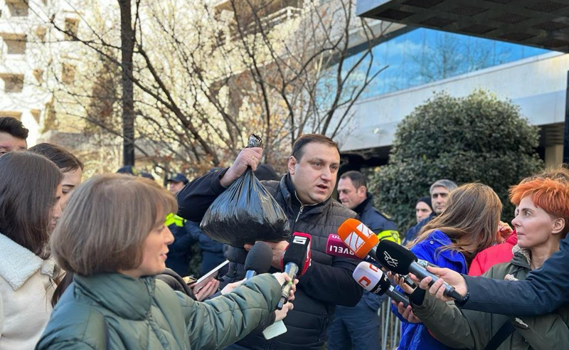 ენმ-ს პერფომანსი - ლაშა ფარულავამ წერეთლის გამზირიდან თბილისის მერიაში კალაძეს მიწა მიუტანა