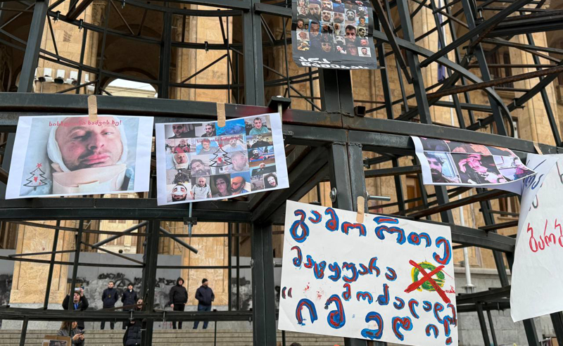 მედიის წარმომადგენლებმა პარლამენტთან, ნაძვის ხის კონსტრუქციაზე ნაცემი ჟურნალისტების ფოტოები და საპროტესტო ბანერები ჩამოკიდეს